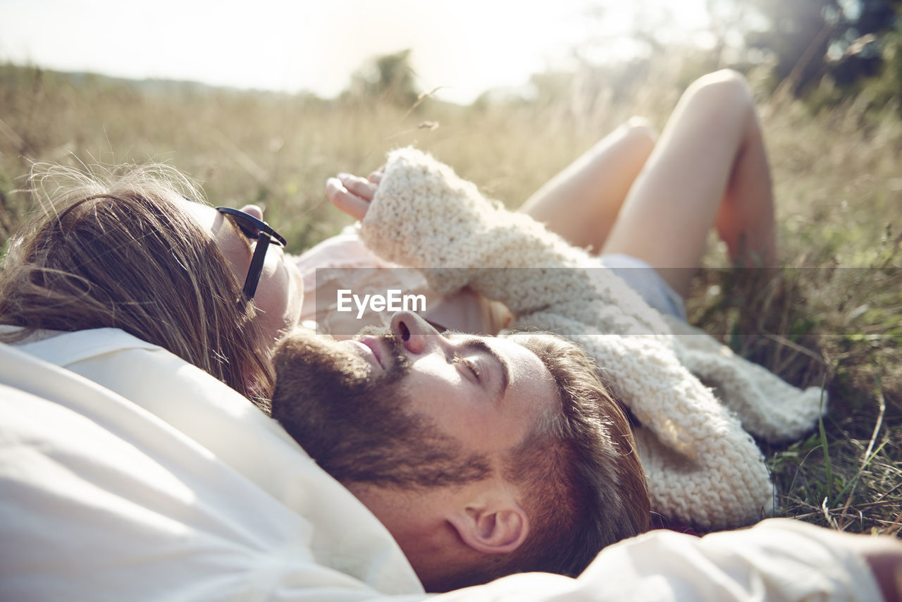 Happy young couple lying in grass