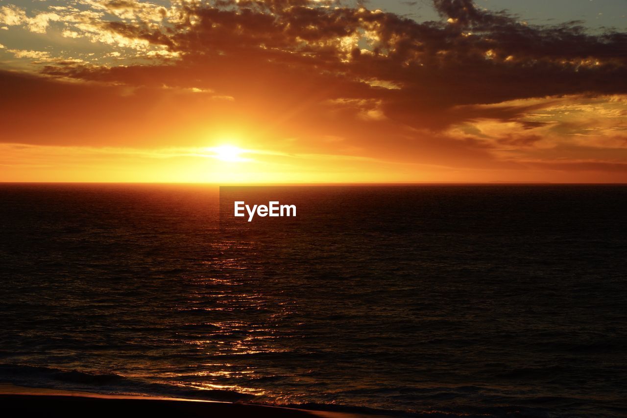 SCENIC VIEW OF SEA AGAINST ORANGE SKY DURING SUNSET