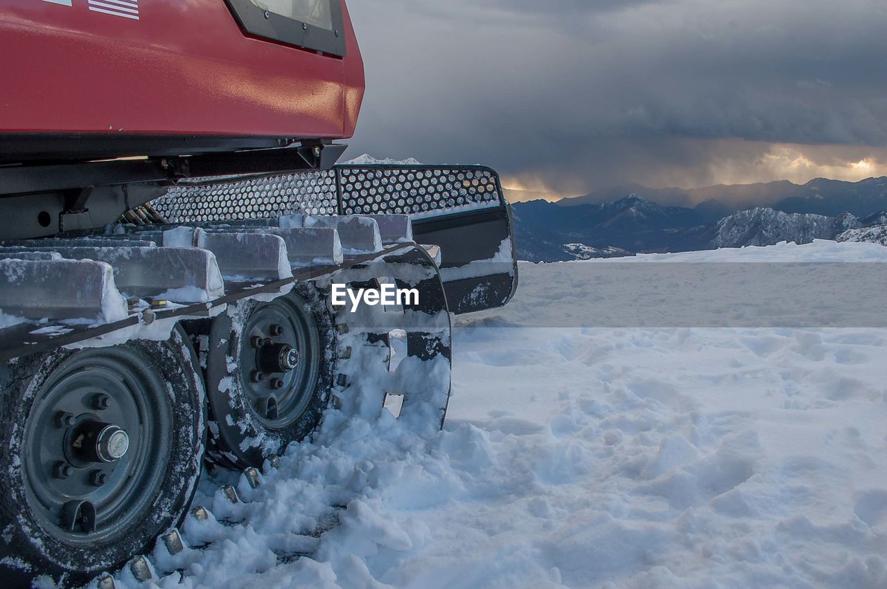Snow covered car on field against sky