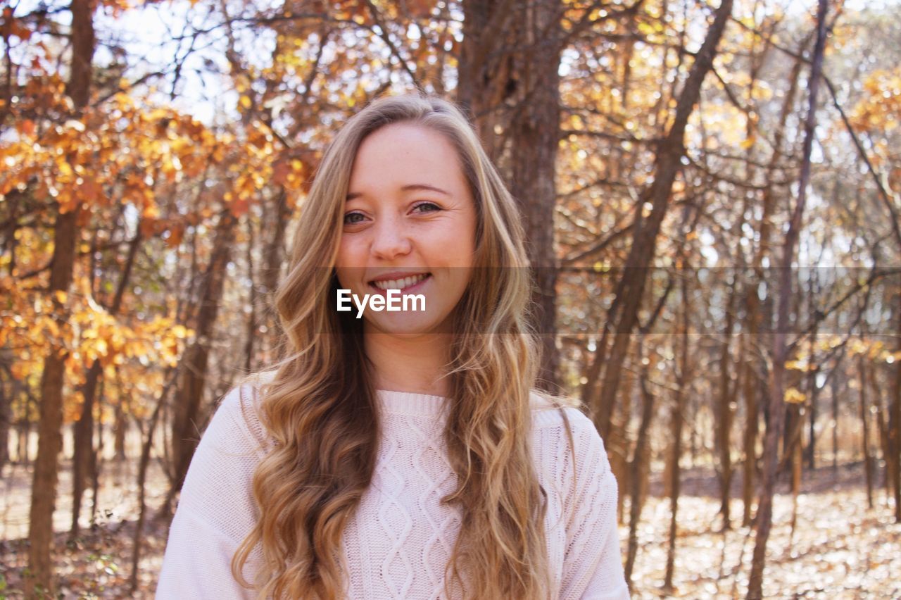 Portrait of smiling young woman in park during autumn