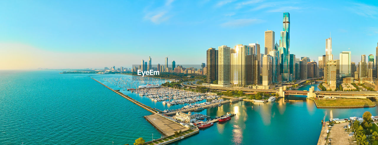 high angle view of city by sea against sky during sunset