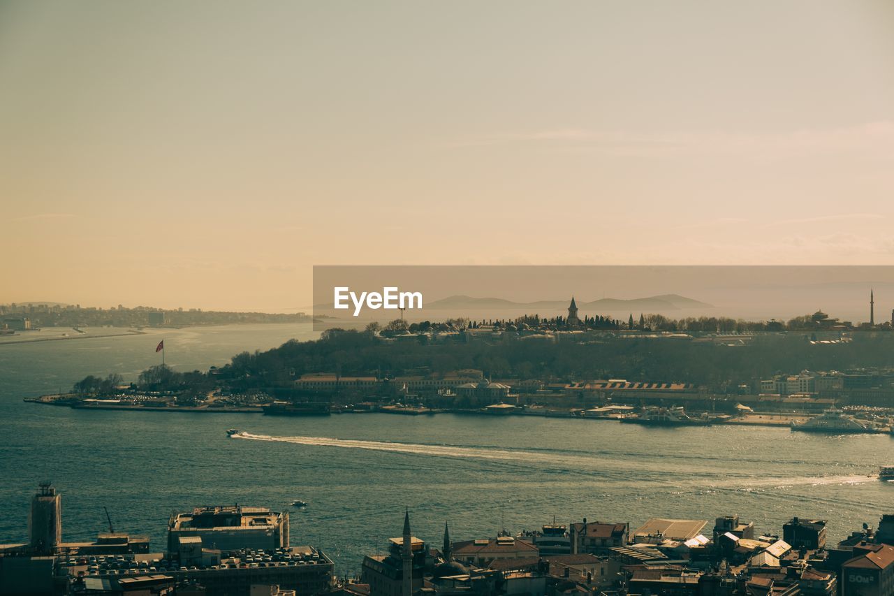 High angle view of city by sea against sky