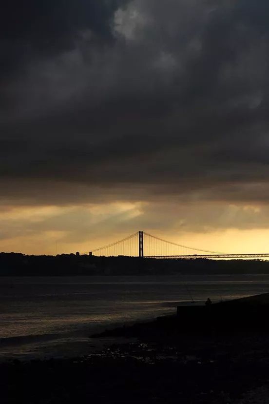VIEW OF BRIDGE OVER SEA AGAINST CLOUDY SKY