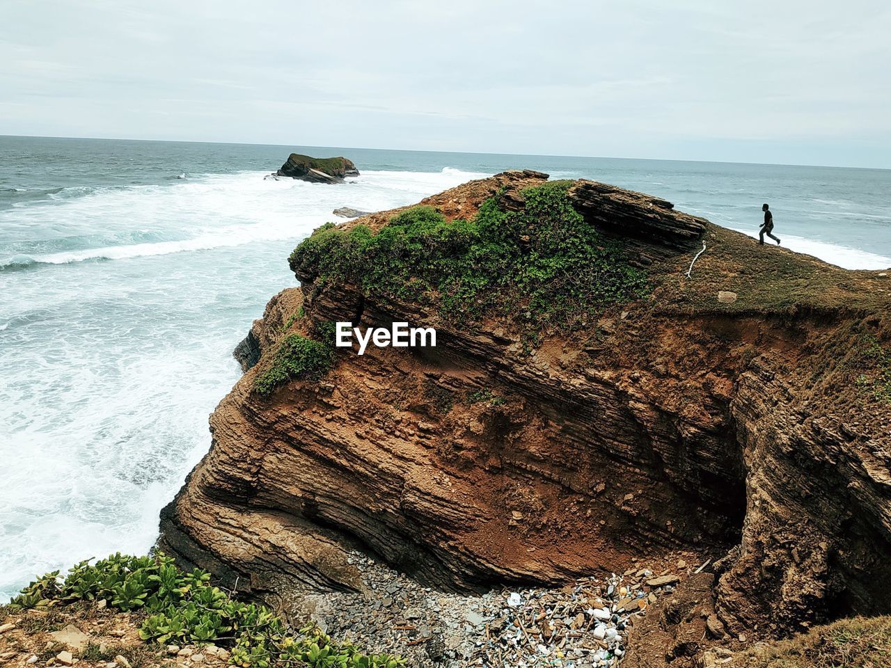 Rock formation on beach against sky