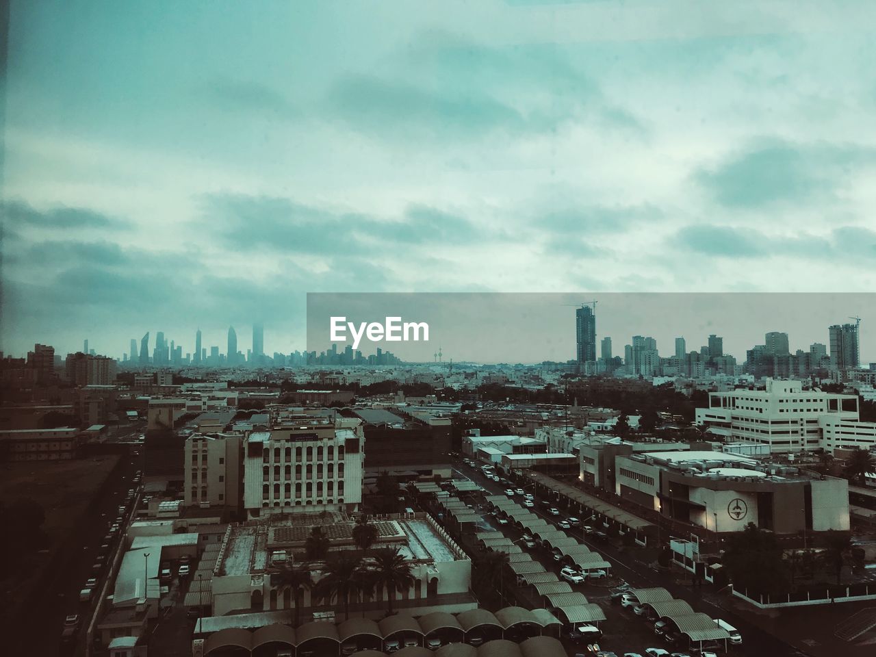 HIGH ANGLE VIEW OF CITY AGAINST CLOUDY SKY