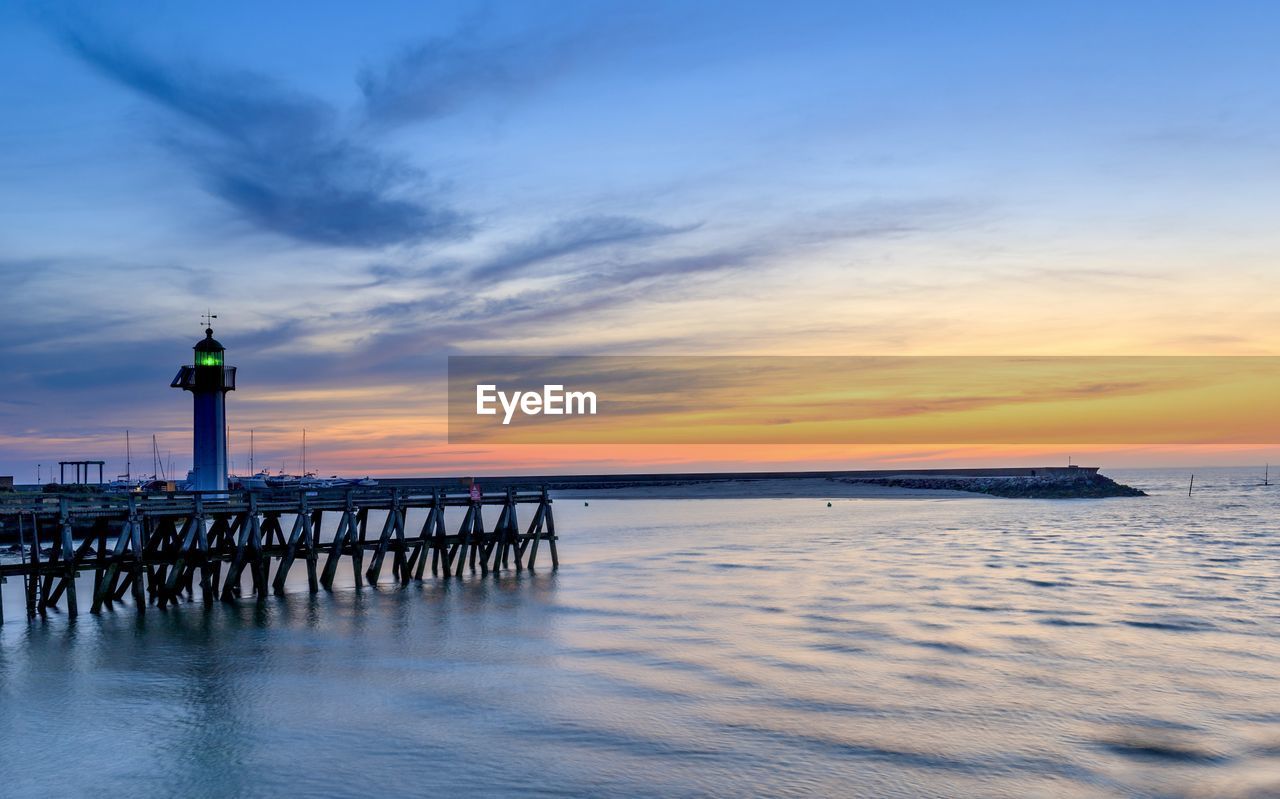 pier on sea against sky during sunset