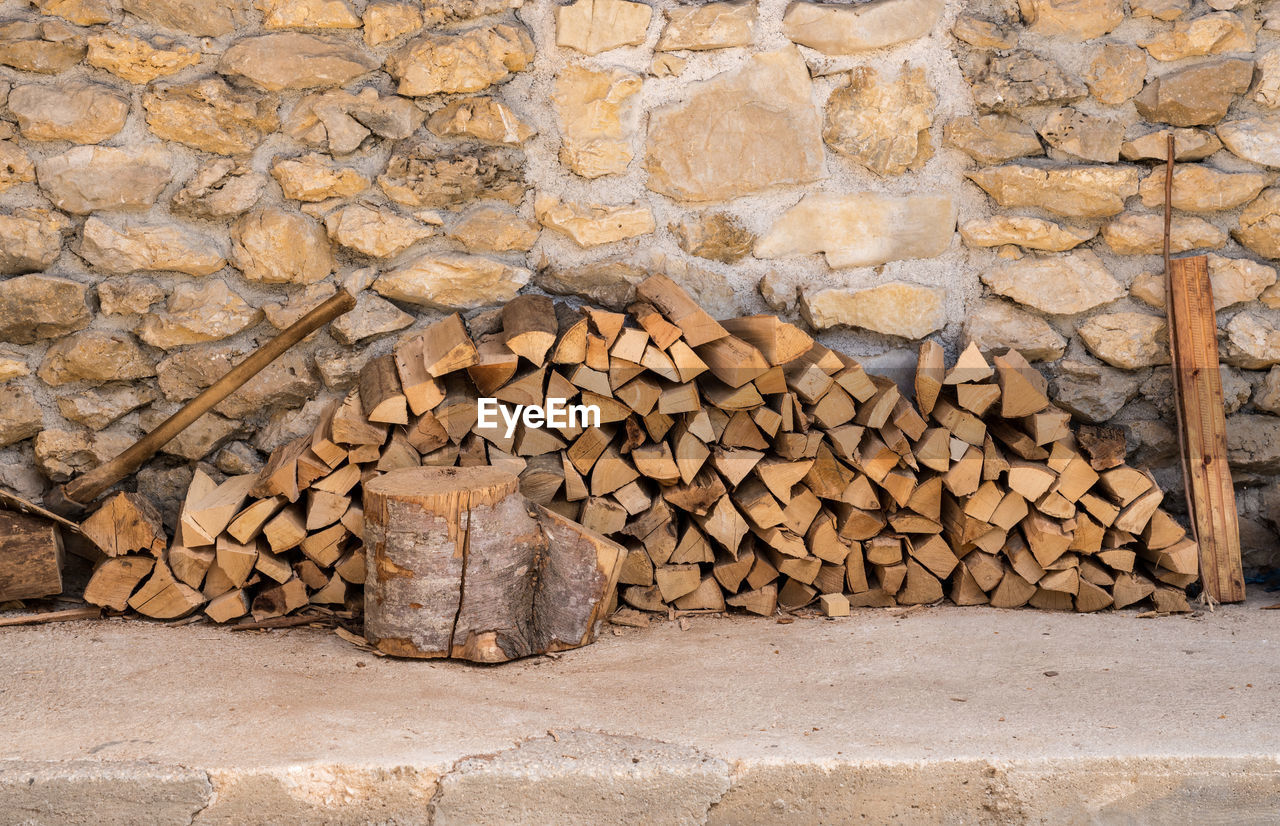 STACK OF LOGS AGAINST WALL