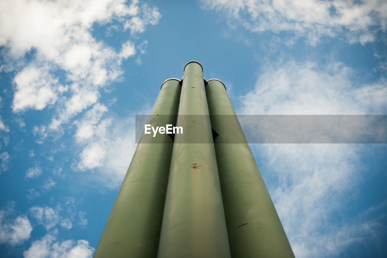 Low angle view of pipes against blue sky