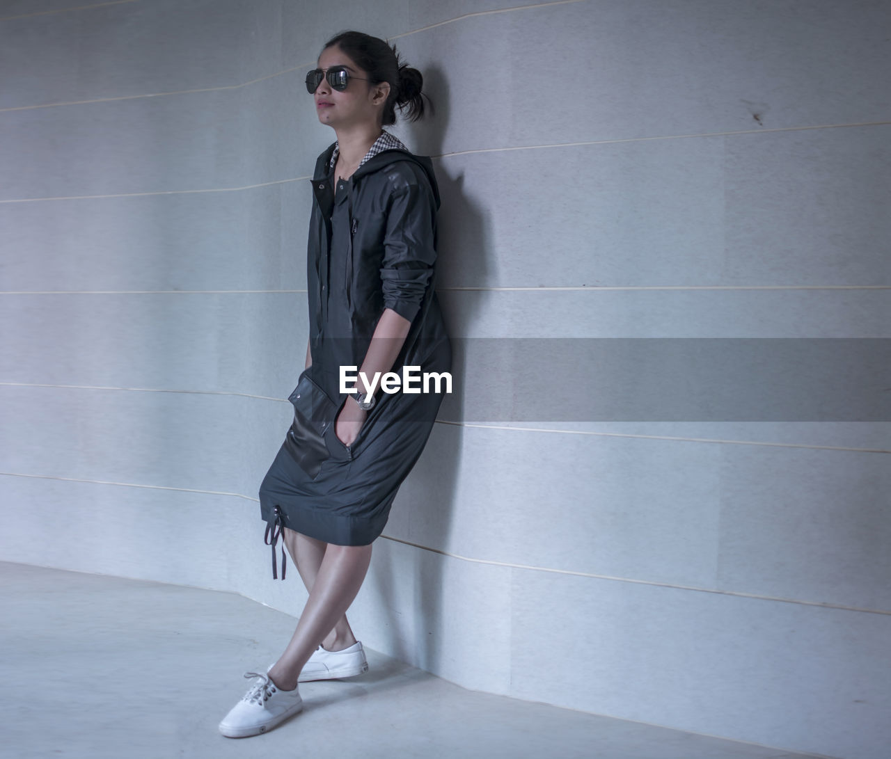 PORTRAIT OF BEAUTIFUL WOMAN STANDING AGAINST WALL