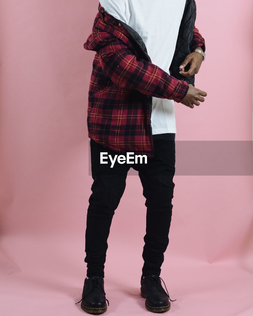 Low section of fashionable man against colored background