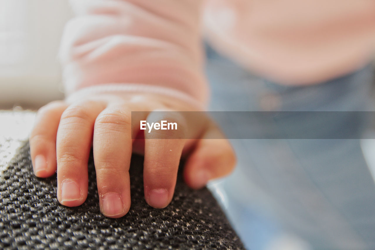 Close-up of girl hand on sofa at home