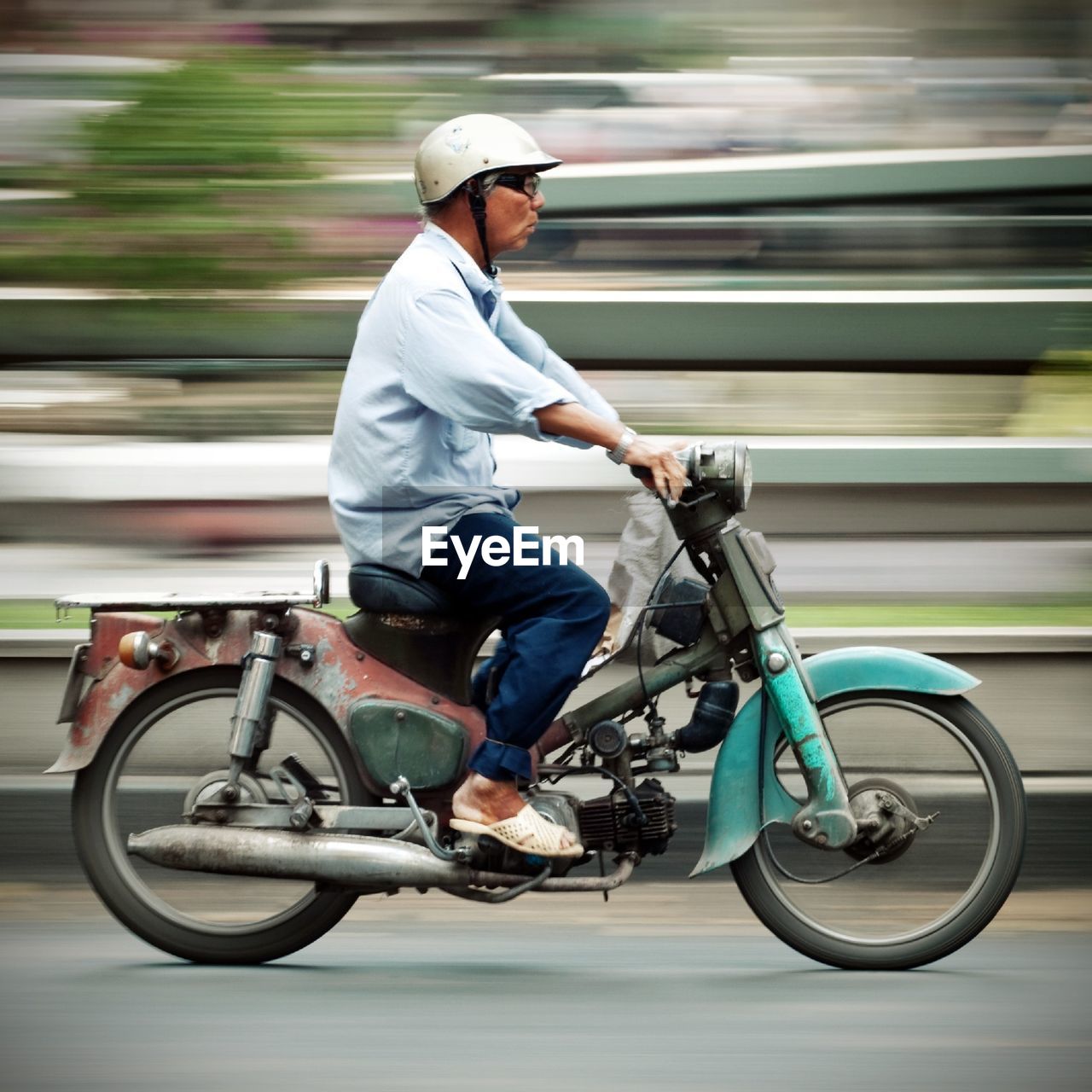 Side view full length of man riding motorcycle on road