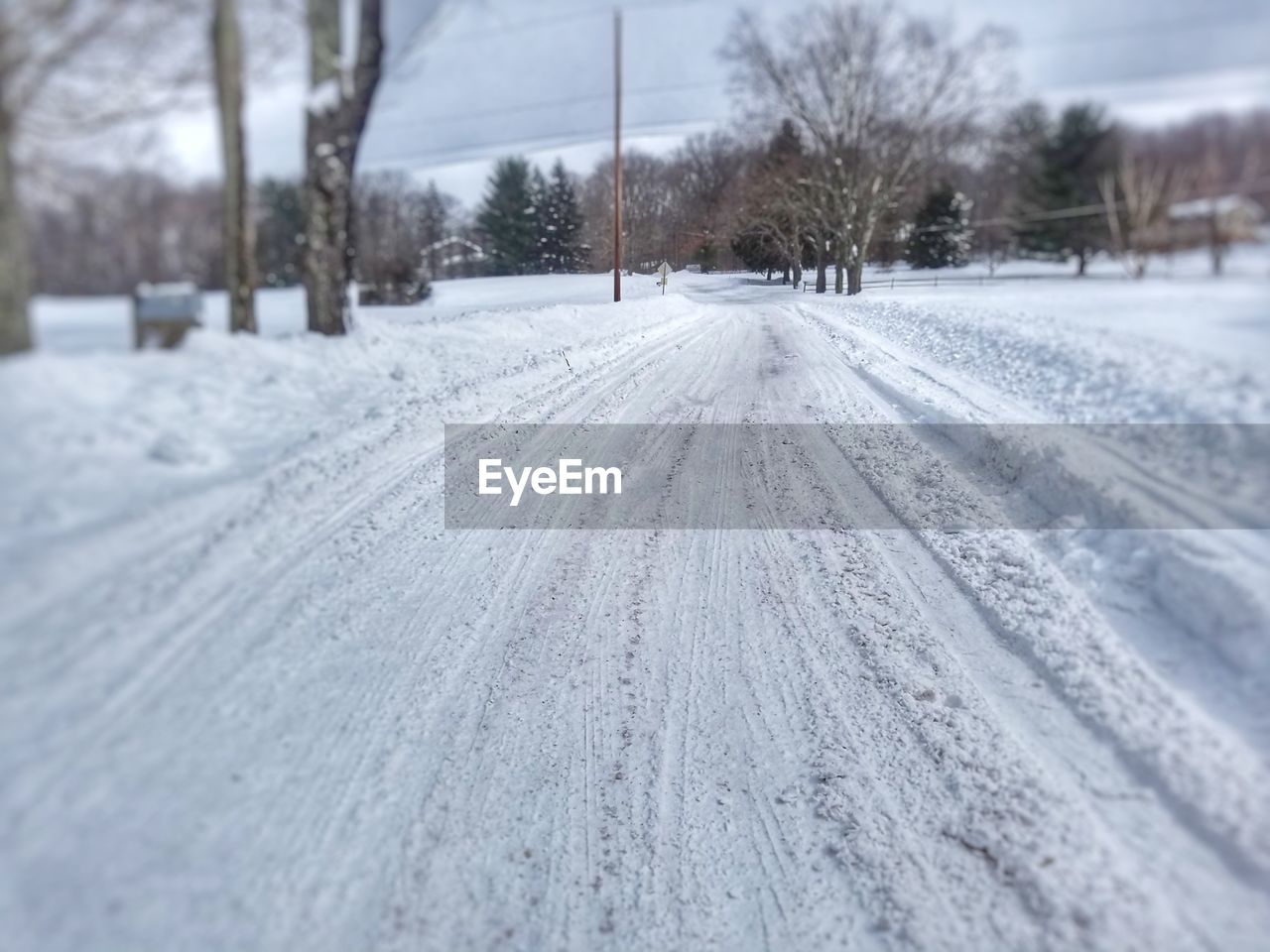 CLOSE-UP OF TIRE TRACKS AGAINST SKY DURING WINTER