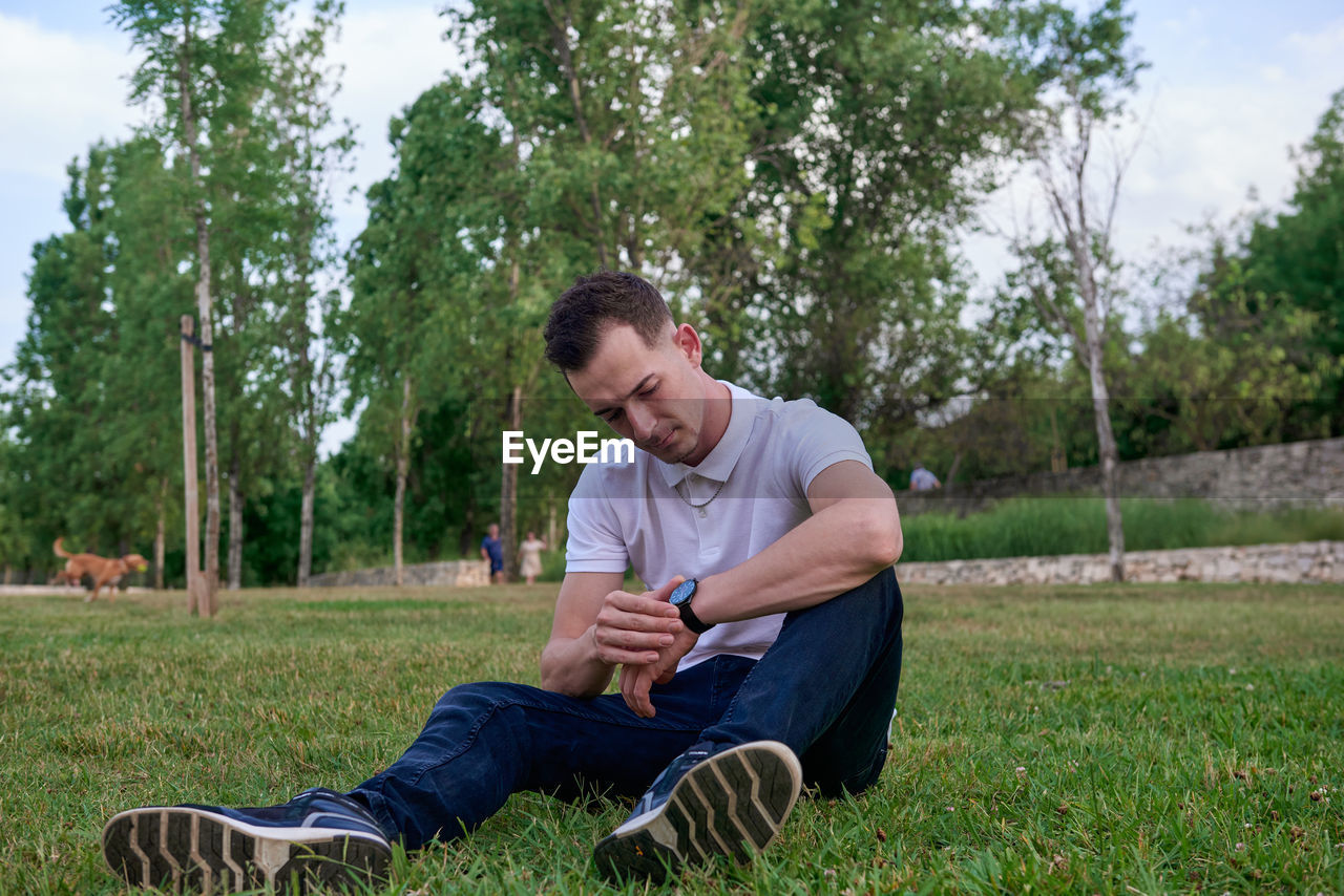 Portrait of young man sitting on field