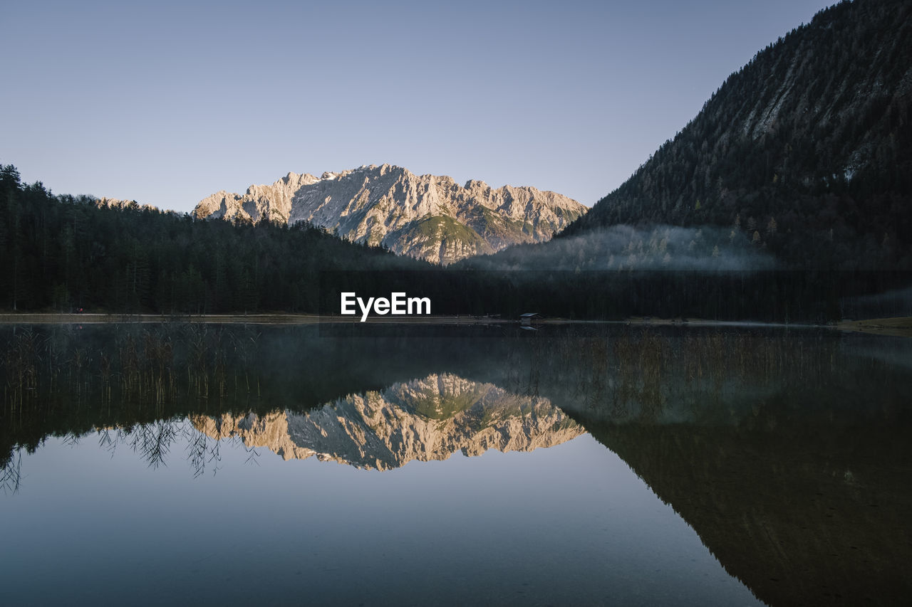 Scenic view of lake and mountains against clear sky