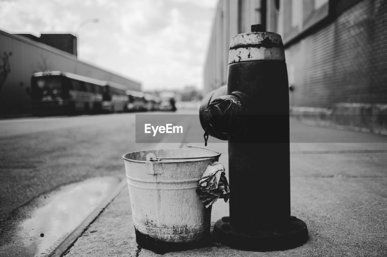 Bucket by fire hydrant on footpath