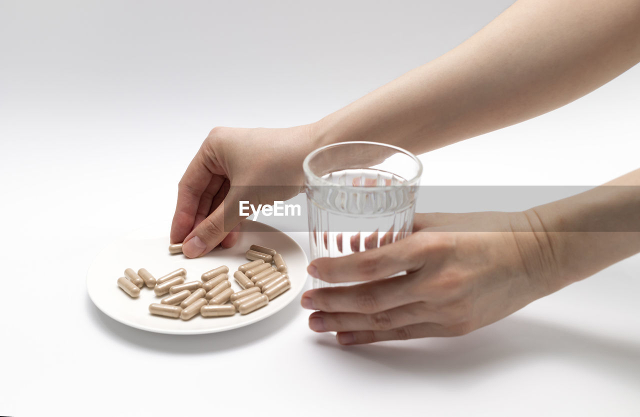 cropped hand of woman holding coffee on table