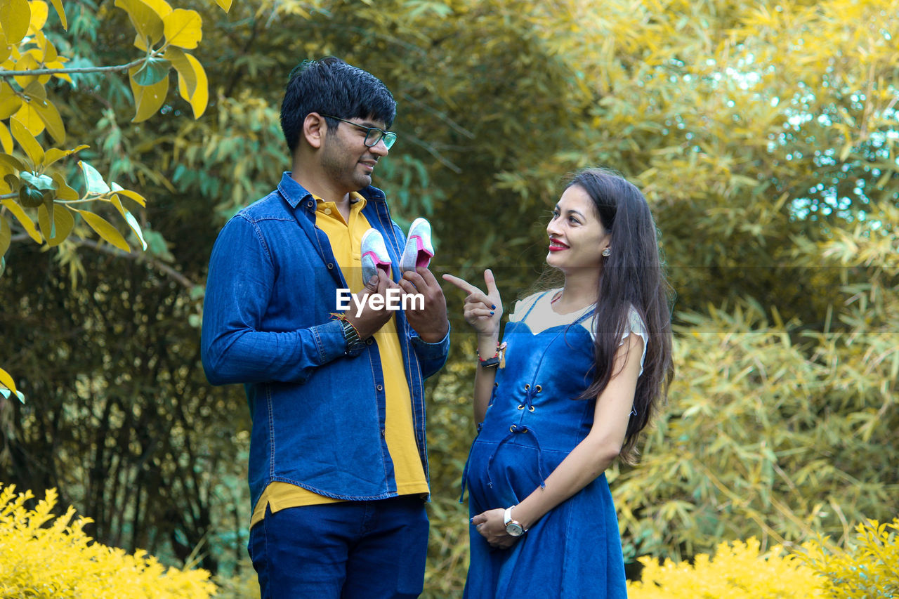 Couple standing against trees in park