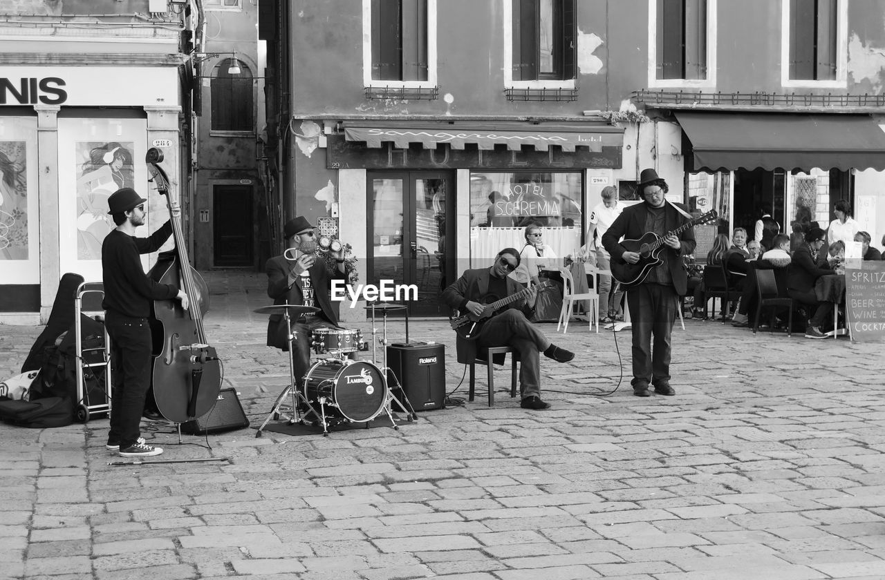 Street musician performing against building in city