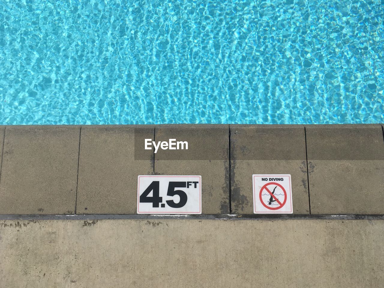No diving sign and number on poolside