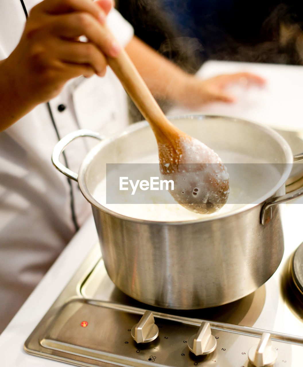 MIDSECTION OF PERSON PREPARING FOOD IN KITCHEN AT HOME