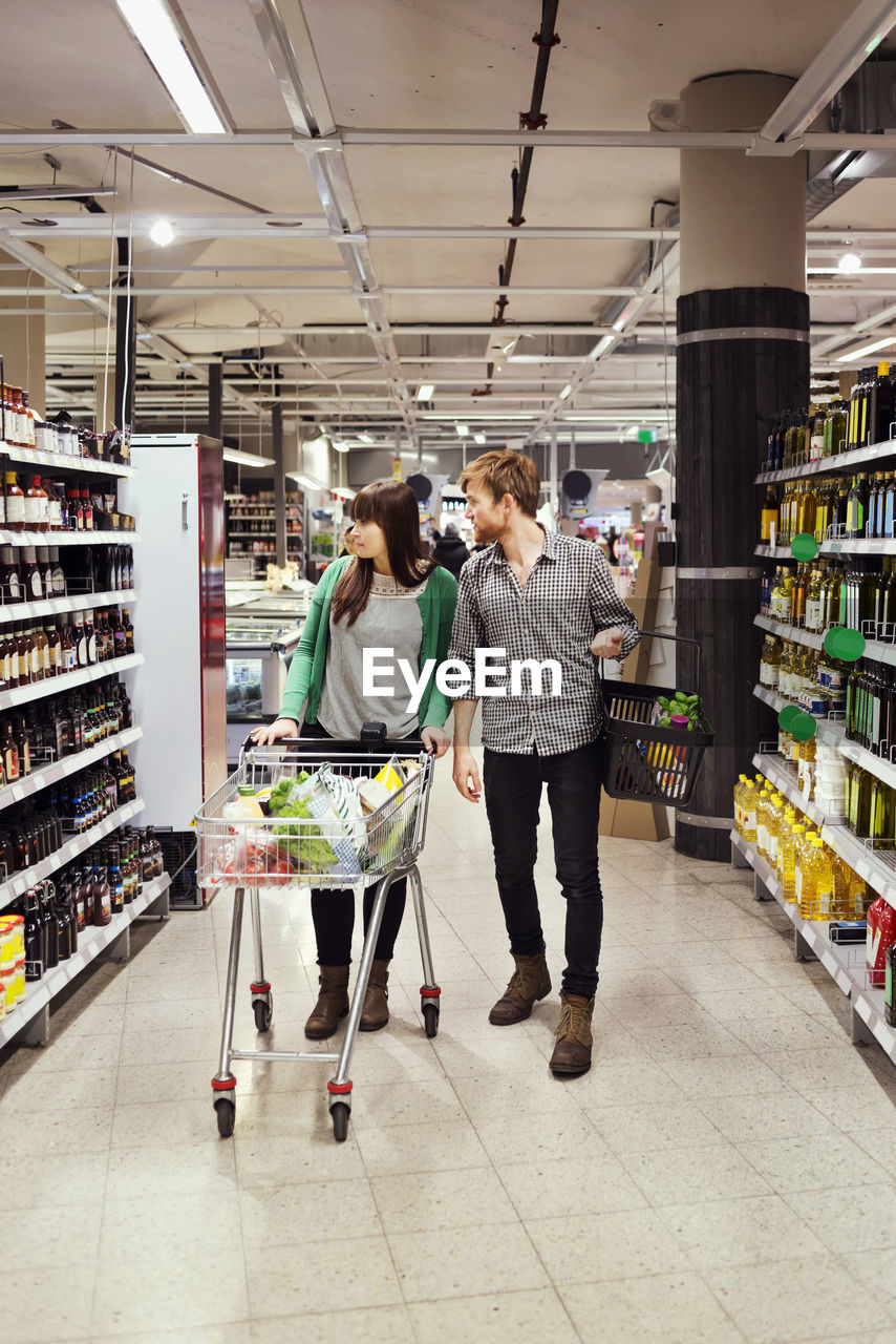 Young couple walking while shopping in supermarket
