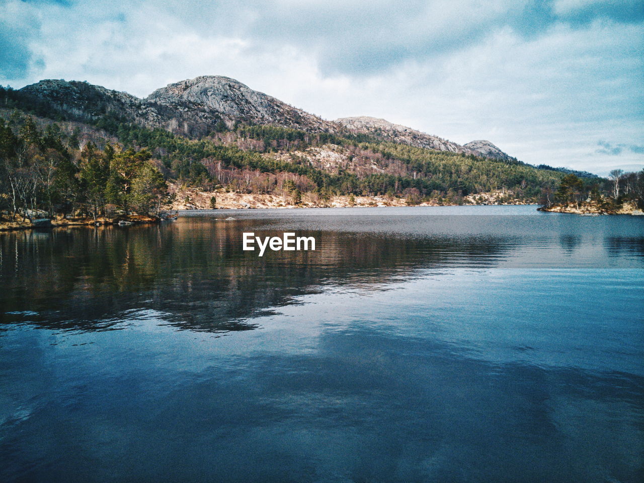 Scenic view of lake by mountain against sky