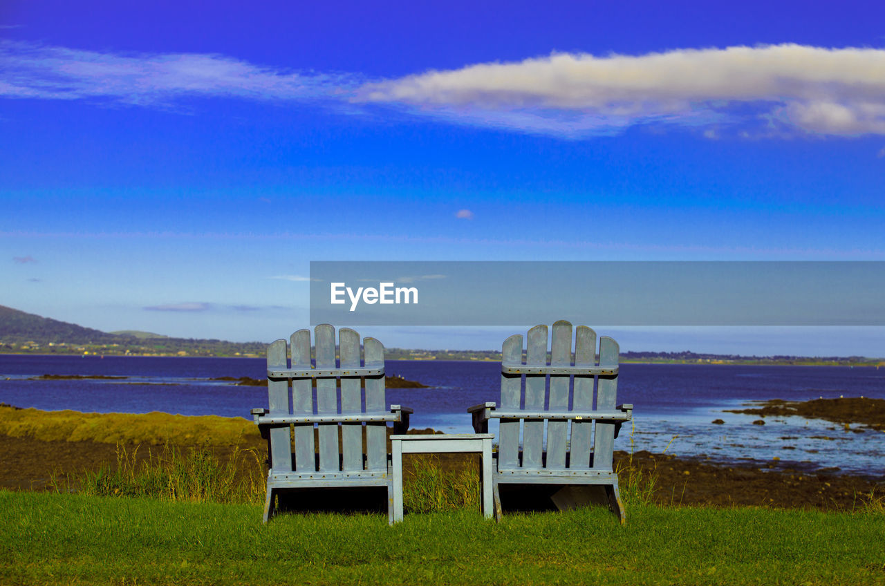 CHAIRS ON BEACH AGAINST SKY