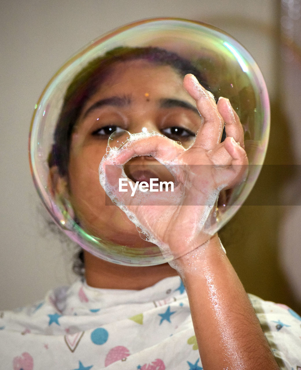 CLOSE-UP PORTRAIT OF A GIRL WITH BUBBLES IN MOUTH