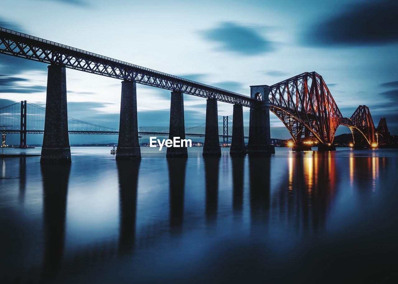Firth of forth rail bridge over river against sky at dusk
