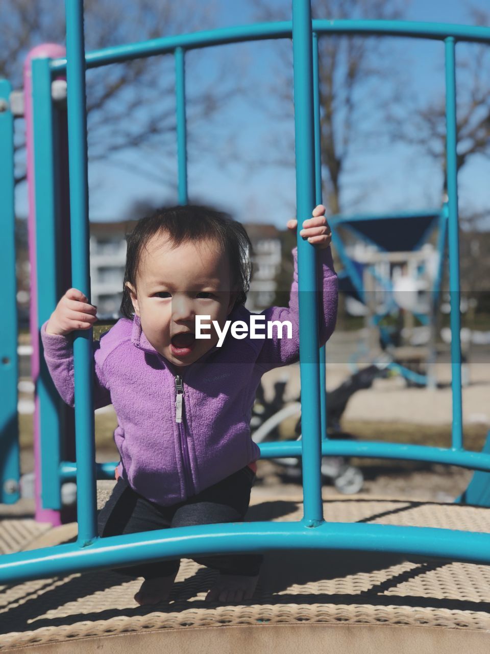 Portrait of baby girl standing on jungle gym at playground