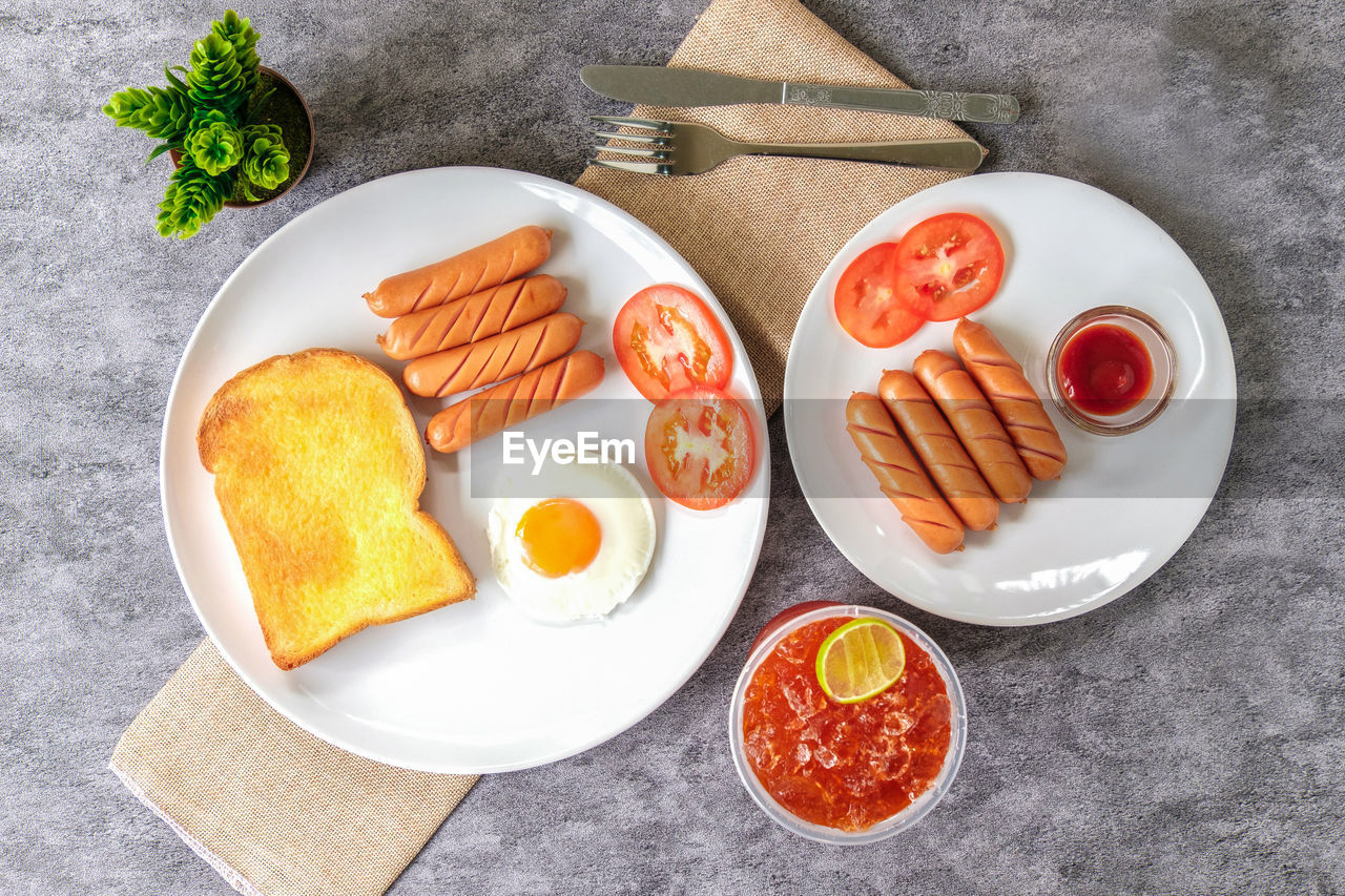 food, food and drink, fast food, healthy eating, plate, dish, meal, high angle view, freshness, meat, vegetable, wellbeing, bread, no people, directly above, fruit, processed meat, produce, breakfast, studio shot, pork, indoors, toasted bread, table, slice, fried, tomato, gray, dairy, baked, egg, gray background, fish, condiment, sausage, cuisine, still life, sauce, snack, lunch, orange