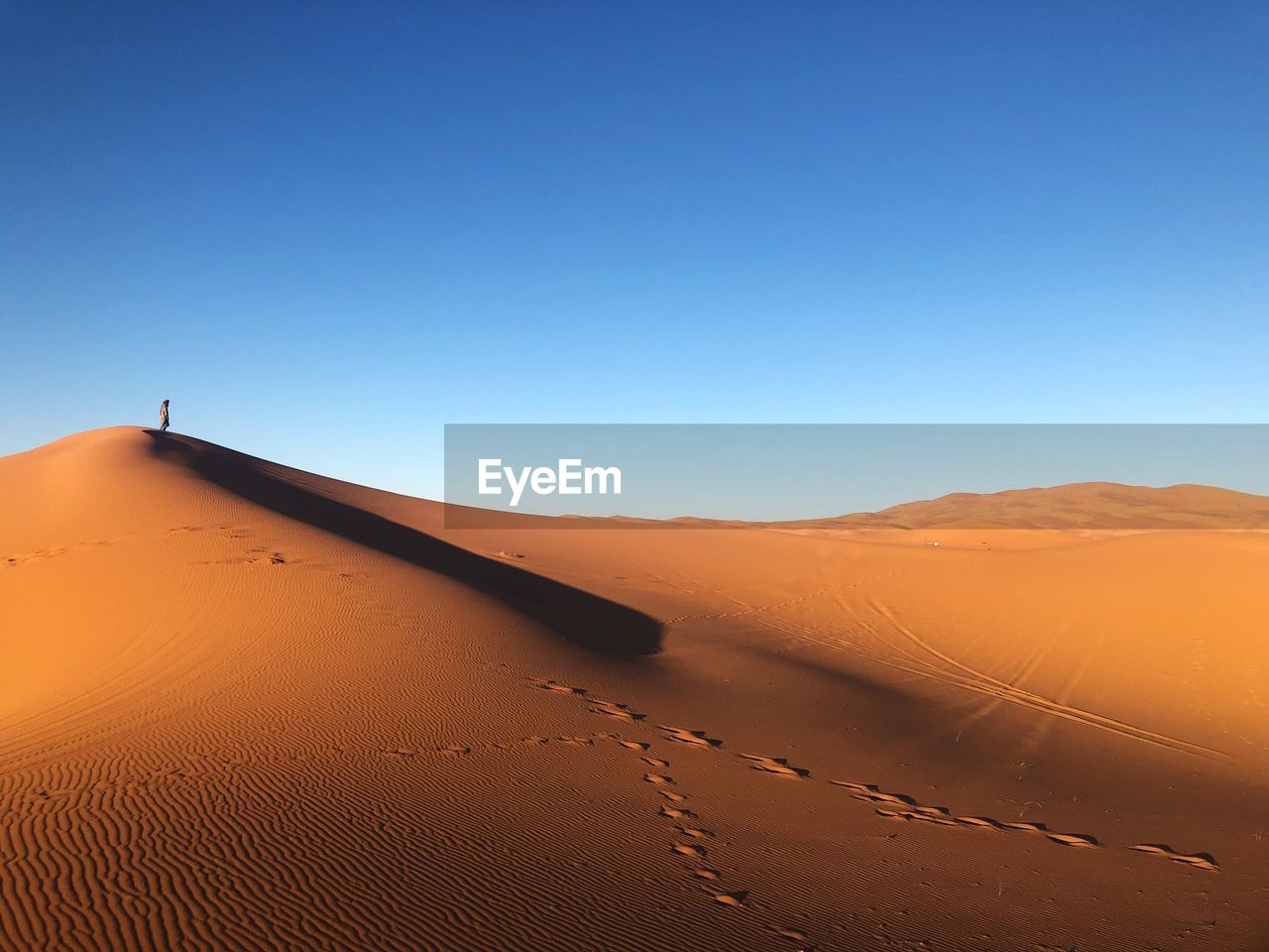 Scenic view of desert against clear blue sky