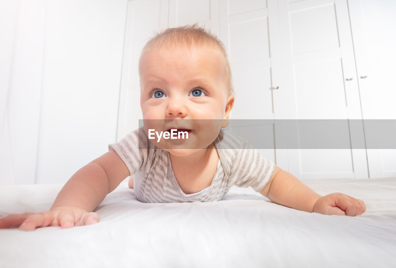 portrait of cute baby boy sleeping on bed at home