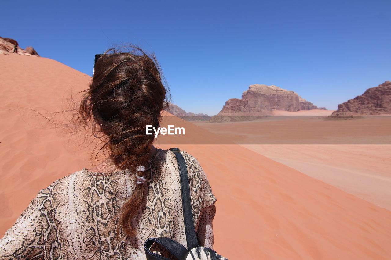 Woman with braided hair walking in the wadi rum desert