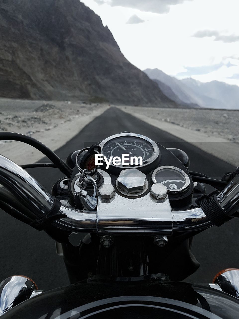 Close-up of motorcycle on road against mountains