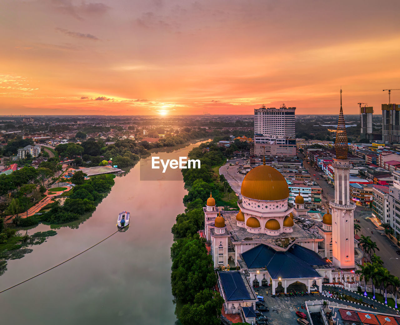 high angle view of townscape by river against sky during sunset