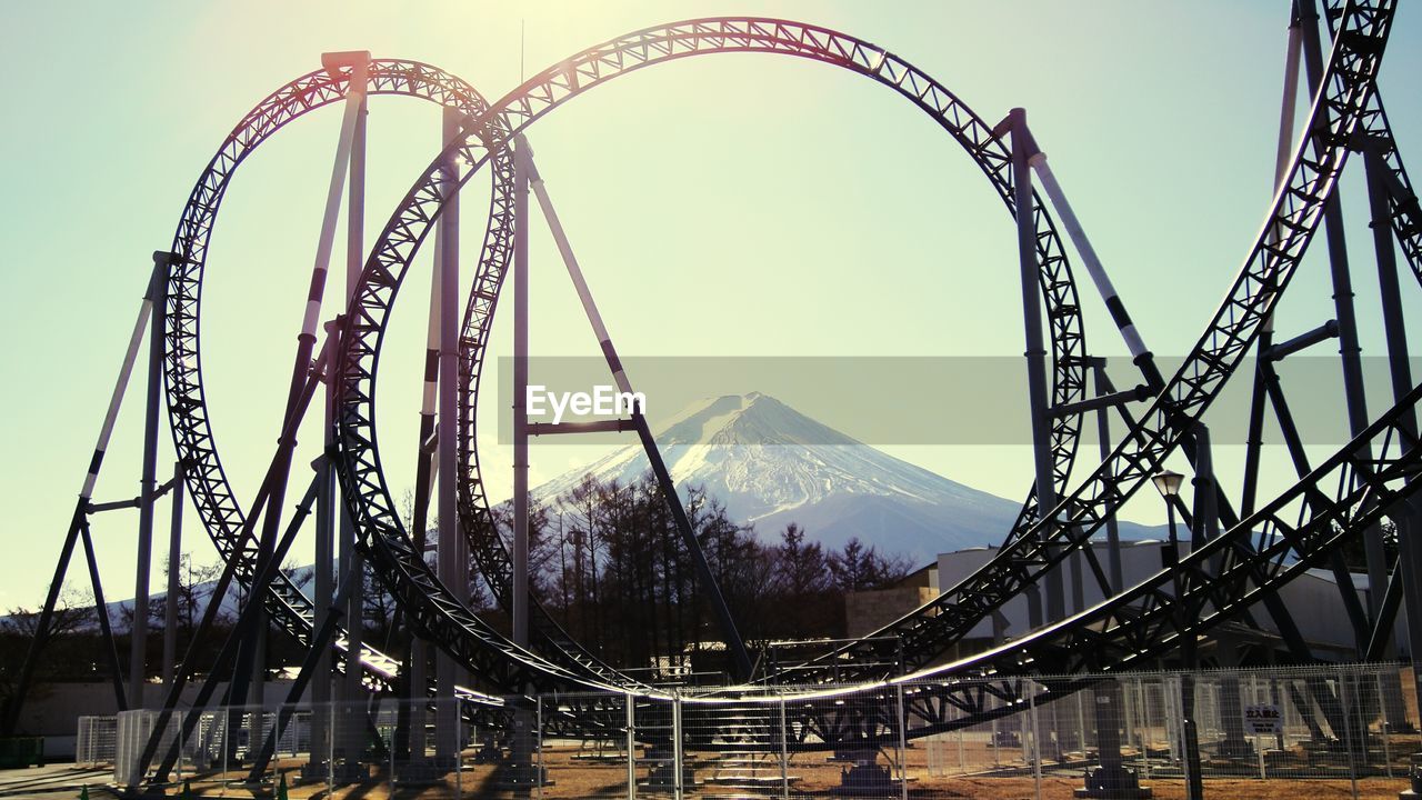 Low angle view of rollercoaster against sky on sunny day