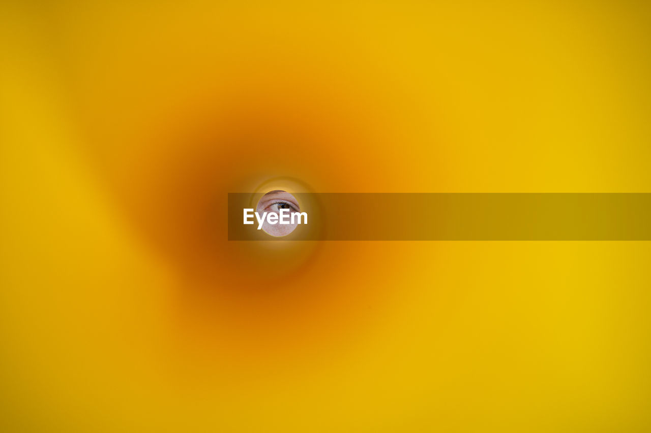 Person peeking through yellow hole