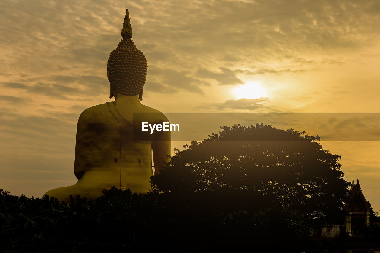 Buddha statue against sky during sunset