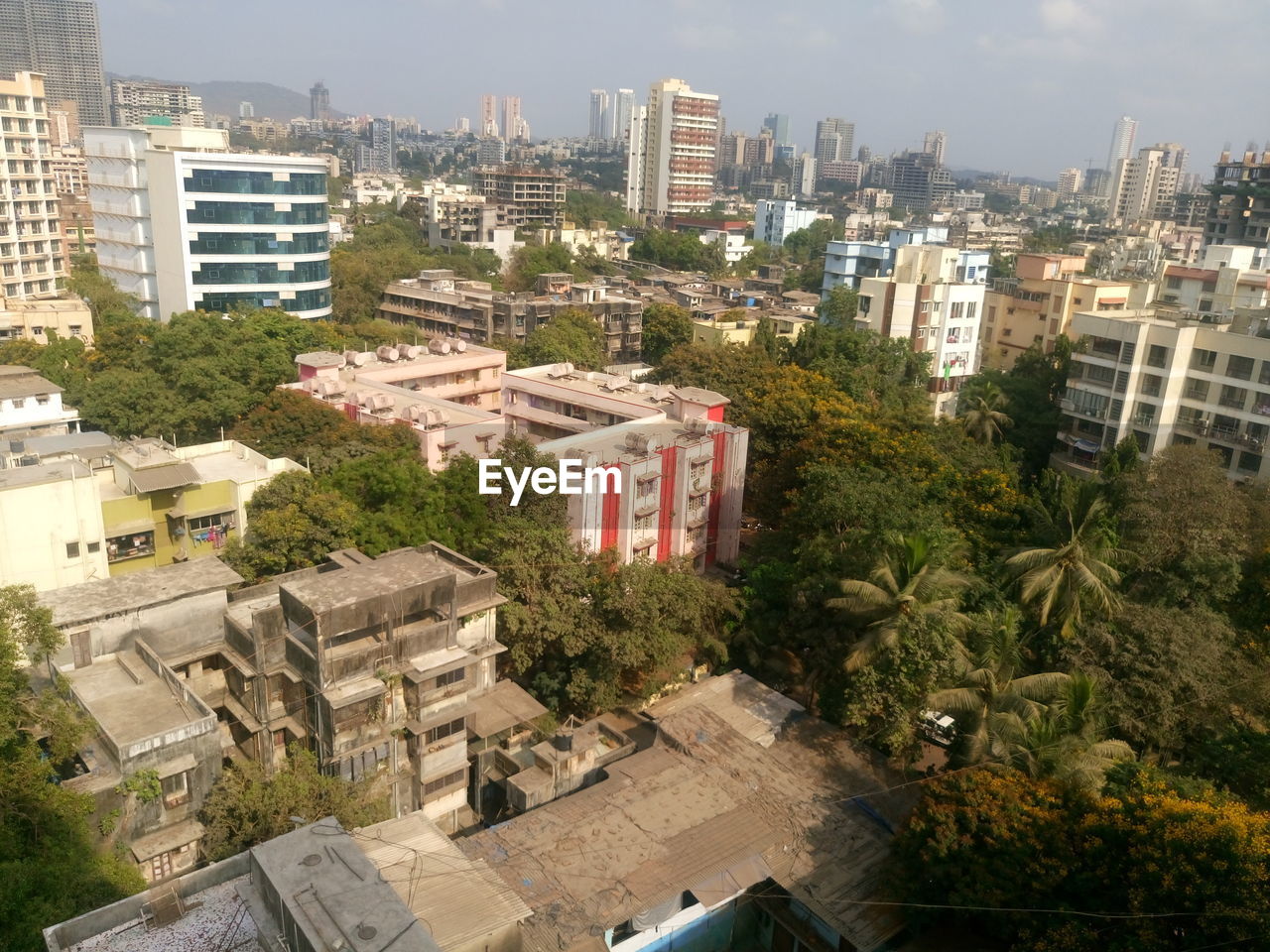 HIGH ANGLE VIEW OF BUILDINGS AND TREES AGAINST SKY