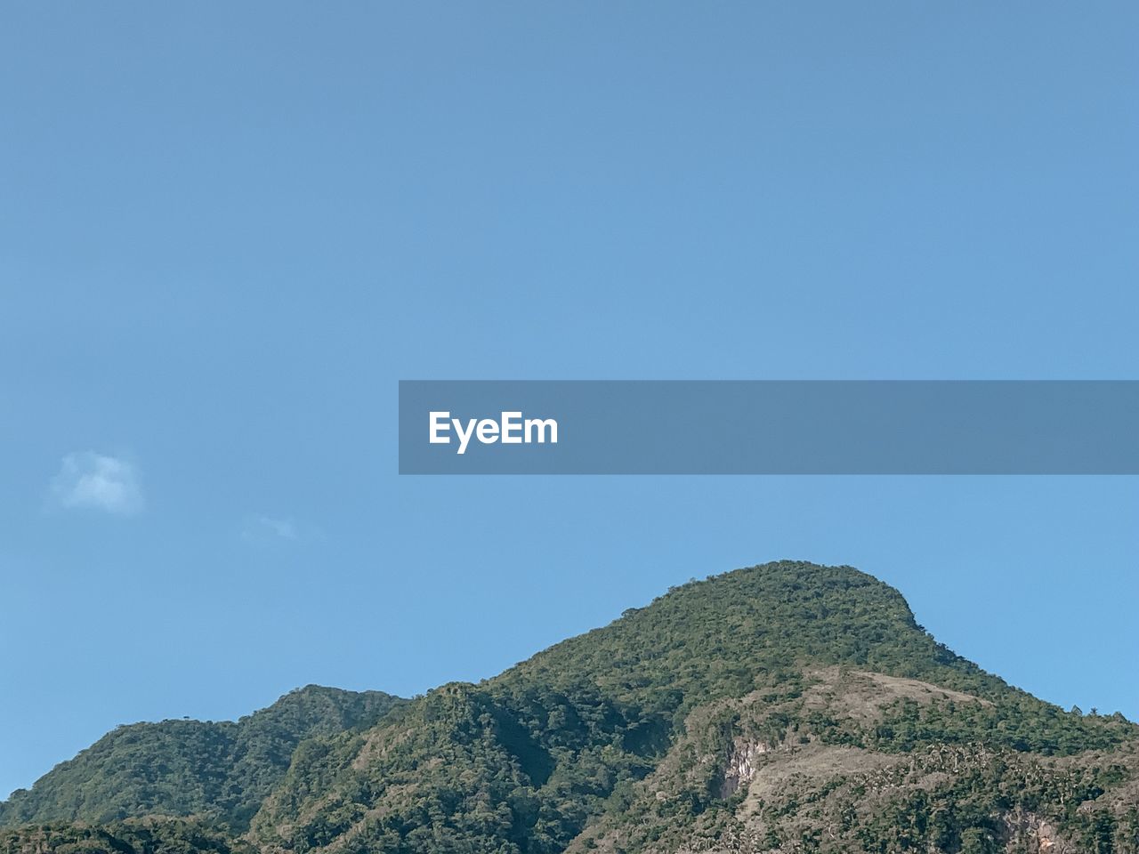 LOW ANGLE VIEW OF MOUNTAINS AGAINST BLUE SKY