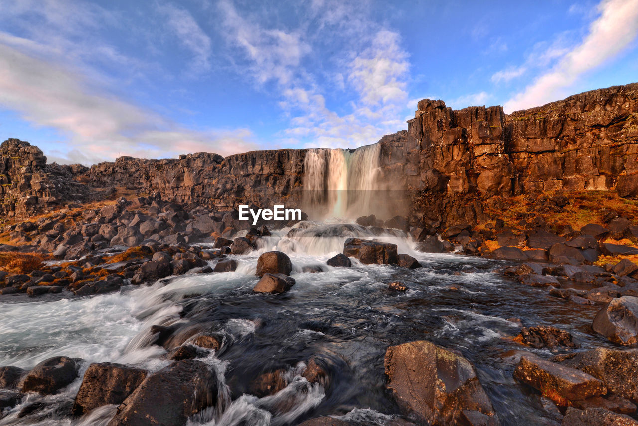 Low angle view of waterfall against sky