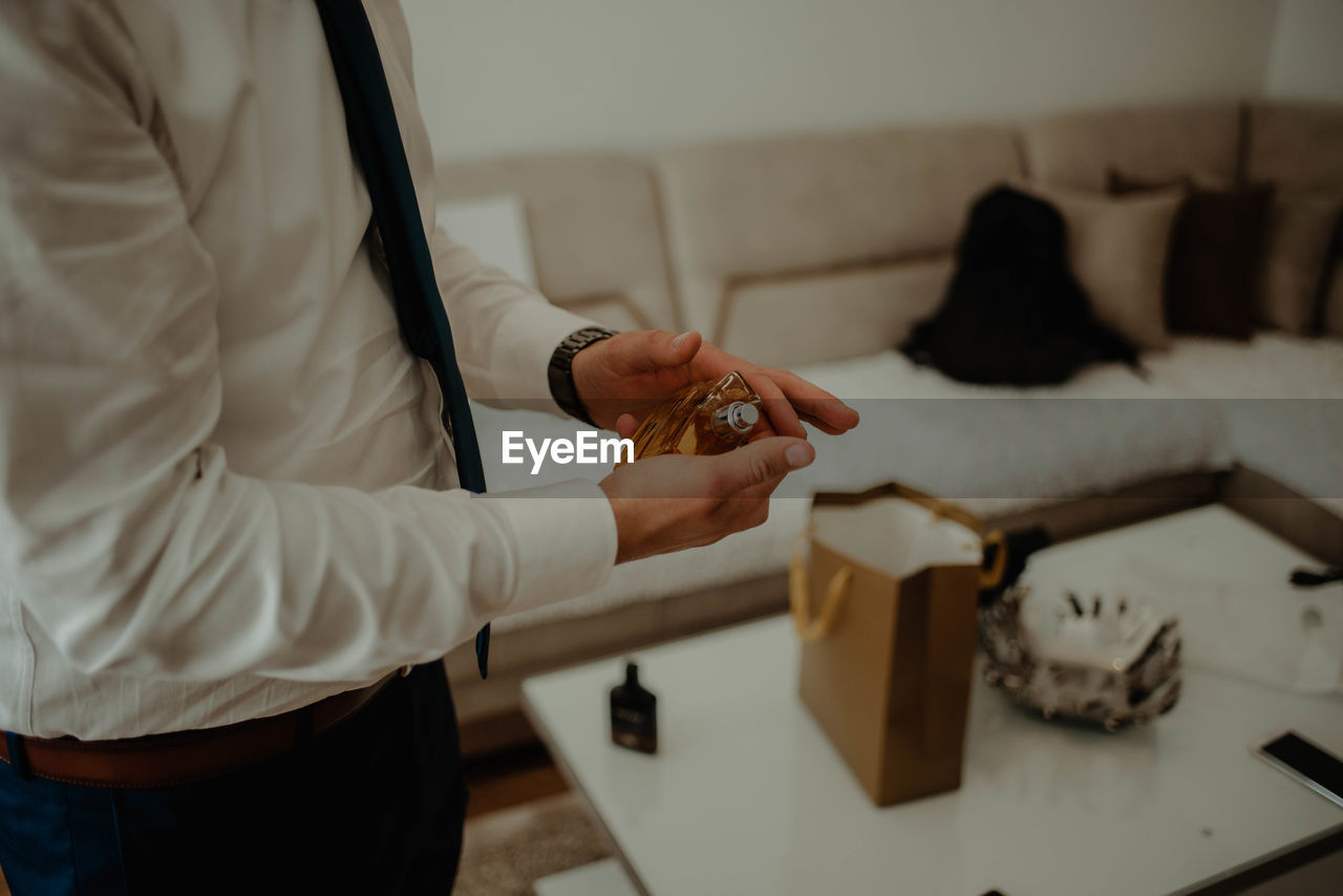 Midsection of man getting ready at home