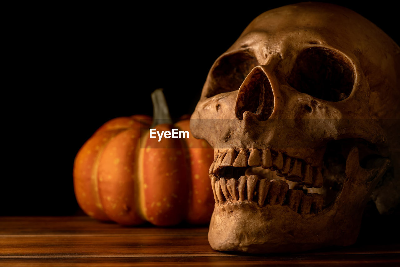 CLOSE-UP OF A PUMPKIN ON TABLE