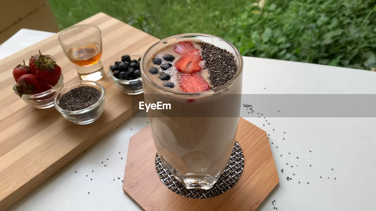 HIGH ANGLE VIEW OF BREAKFAST IN GLASS ON TABLE AGAINST WALL