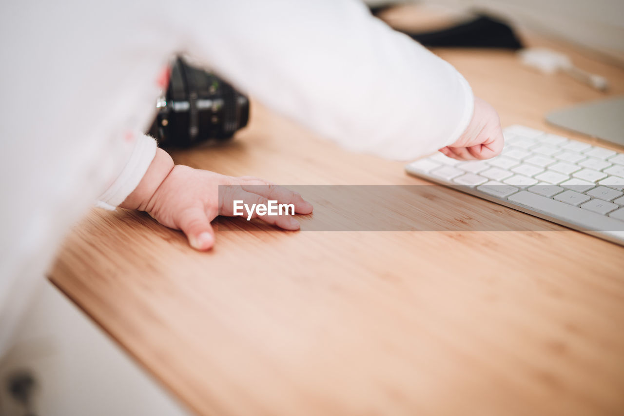 Midsection of baby using laptop on table