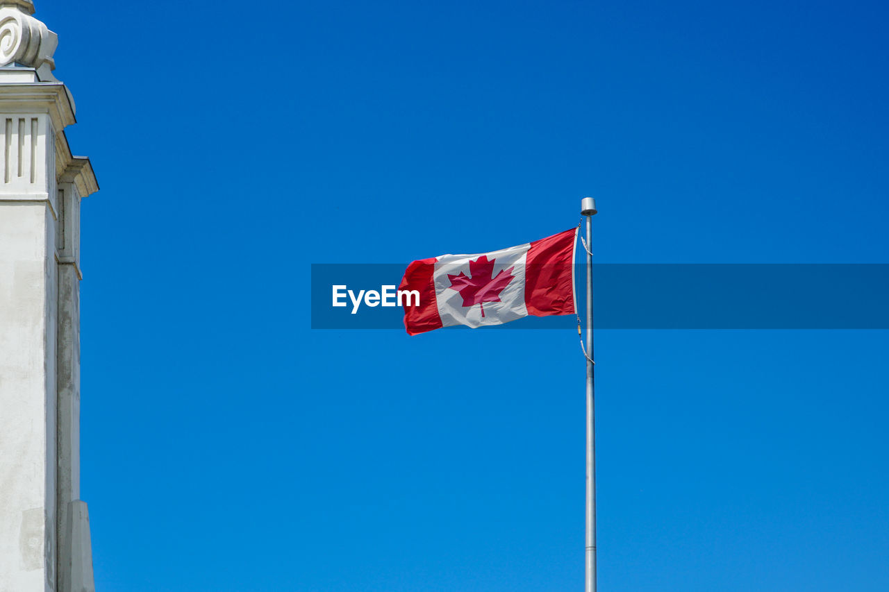 LOW ANGLE VIEW OF FLAG FLAGS AGAINST CLEAR BLUE SKY