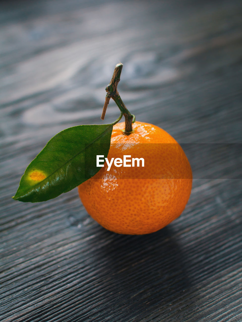 CLOSE-UP OF ORANGE FRUIT ON LEAF