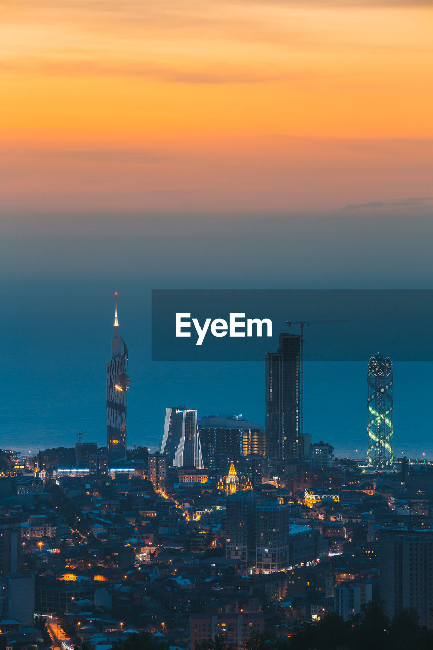 high angle view of illuminated buildings against sky during sunset